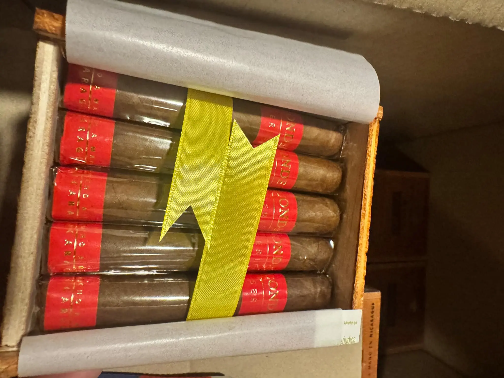 Pairing Your Cigar with Beverages - A Guide to the Perfect Cigar & Drink Pairing 4 Condega products neatly arranged in an open wooden box, highlighting the red and gold bands and yellow ribbon.